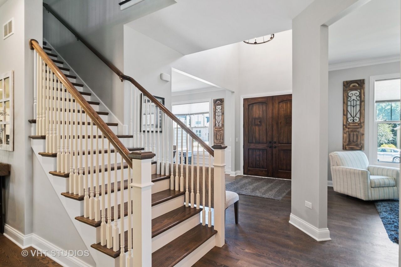 A staircase in a house with a white railing and wooden steps