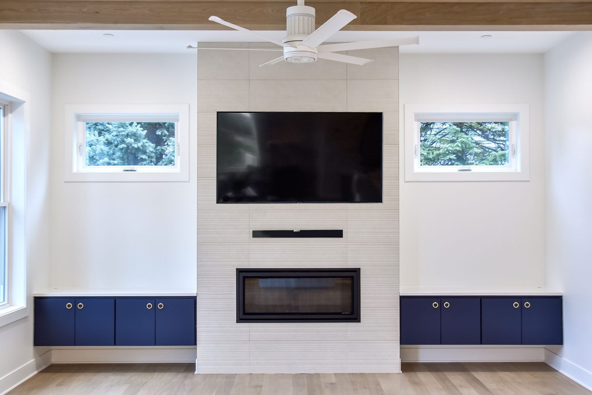 A living room with a fireplace and a flat screen tv on the wall.