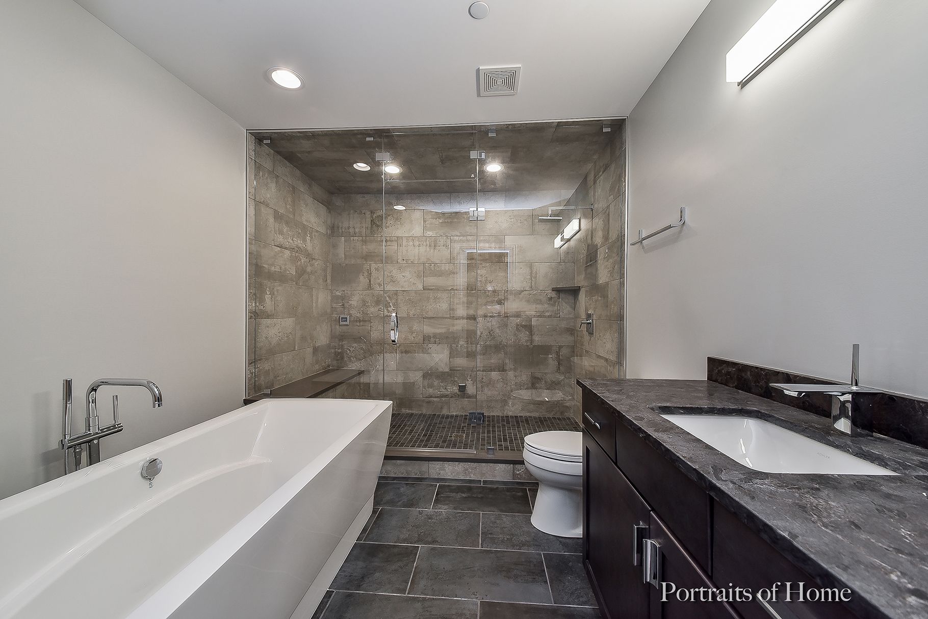 A bathroom with a bathtub , toilet , sink and shower.