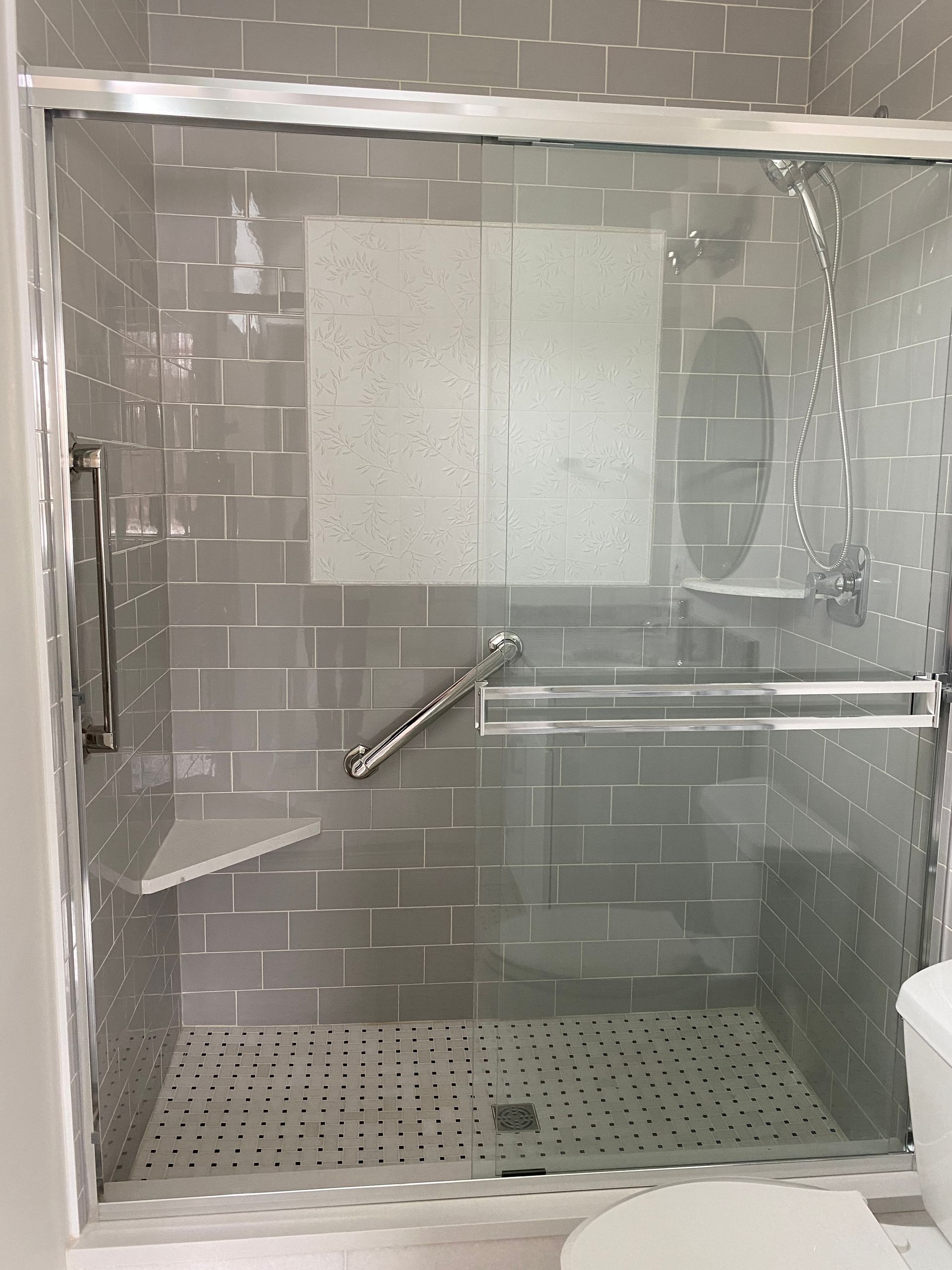 A bathroom with a sliding glass shower door and a toilet.