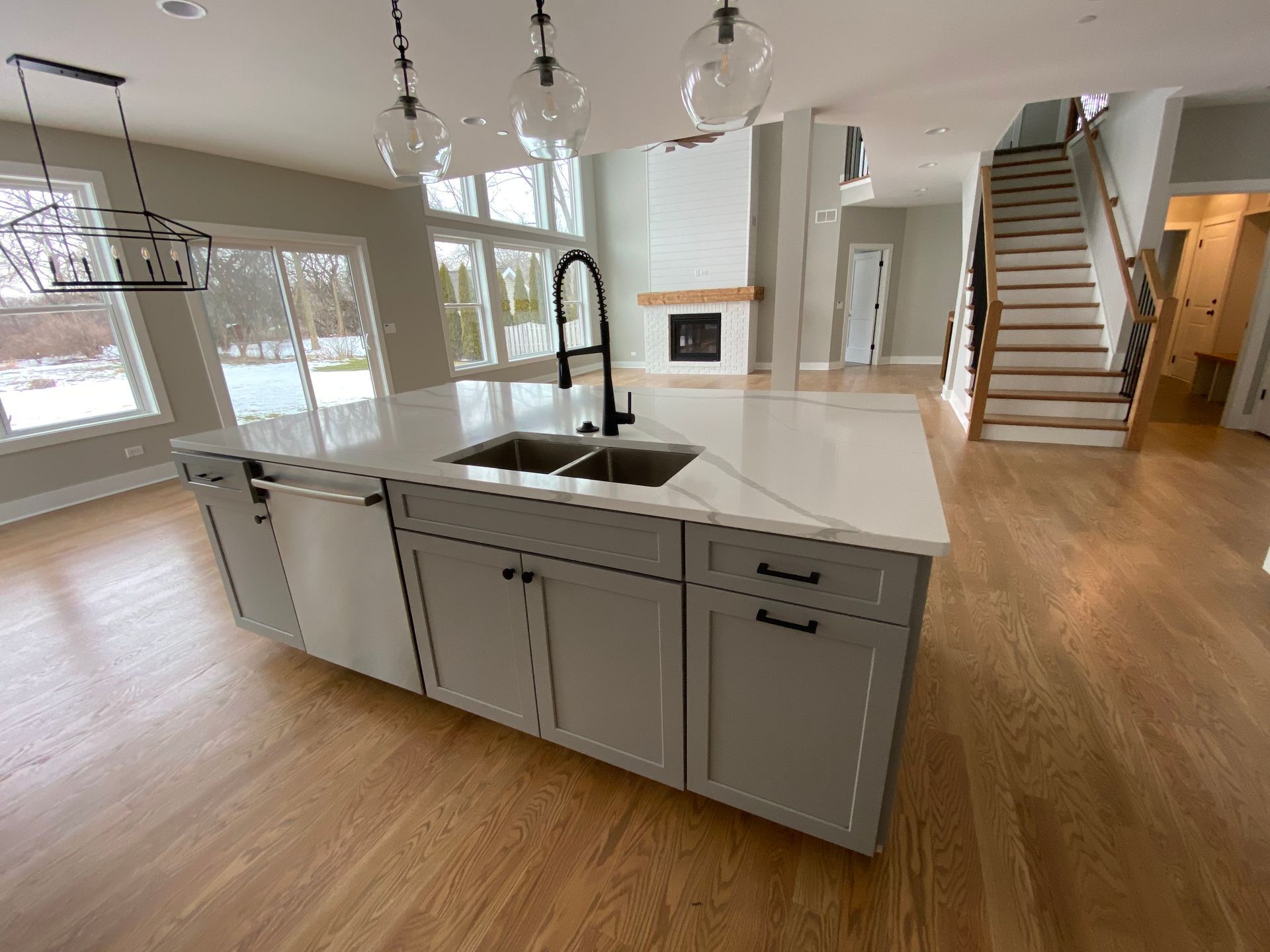 A kitchen with a sink and stairs in the background.