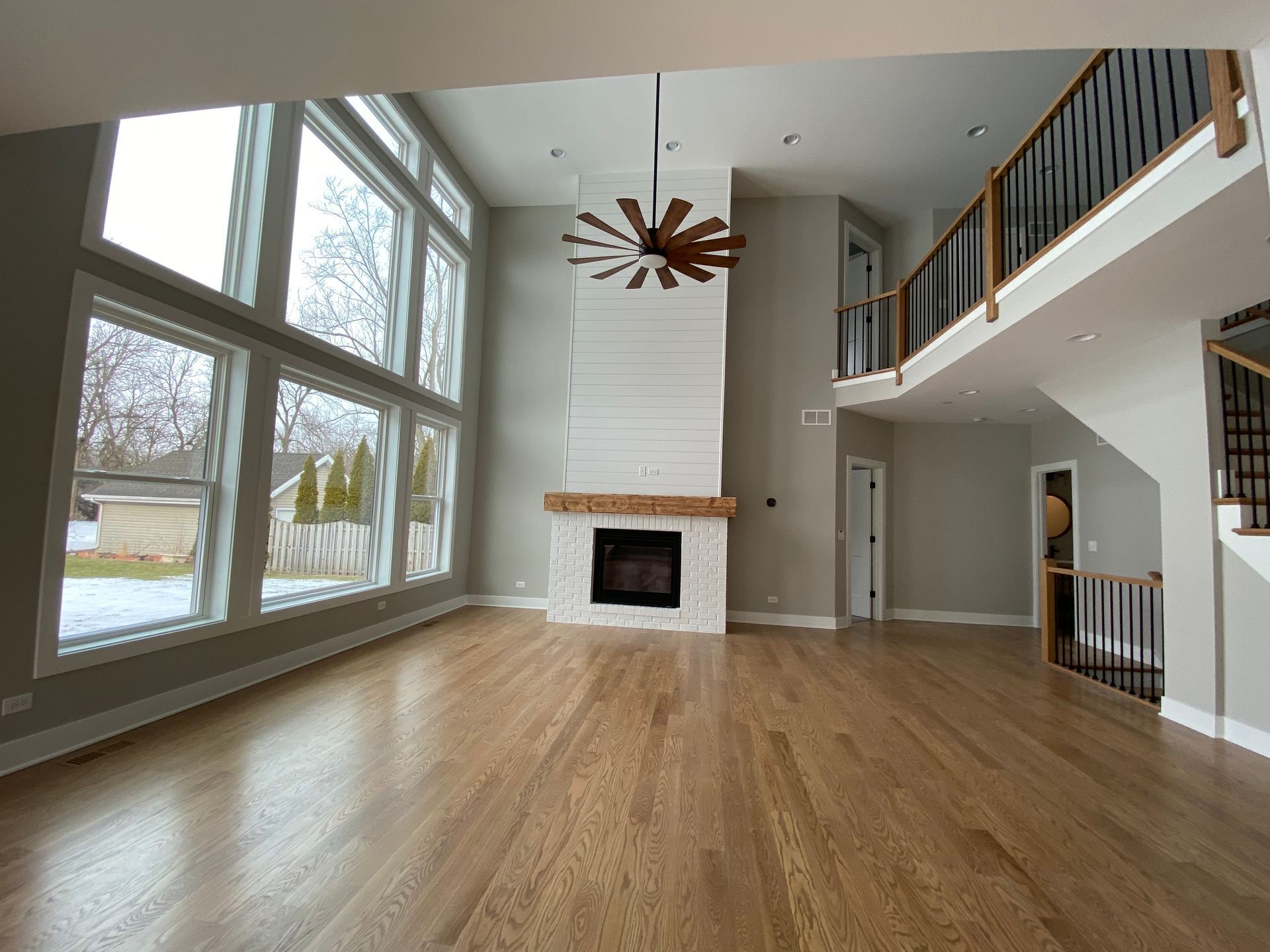 An empty living room with hardwood floors and a fireplace.