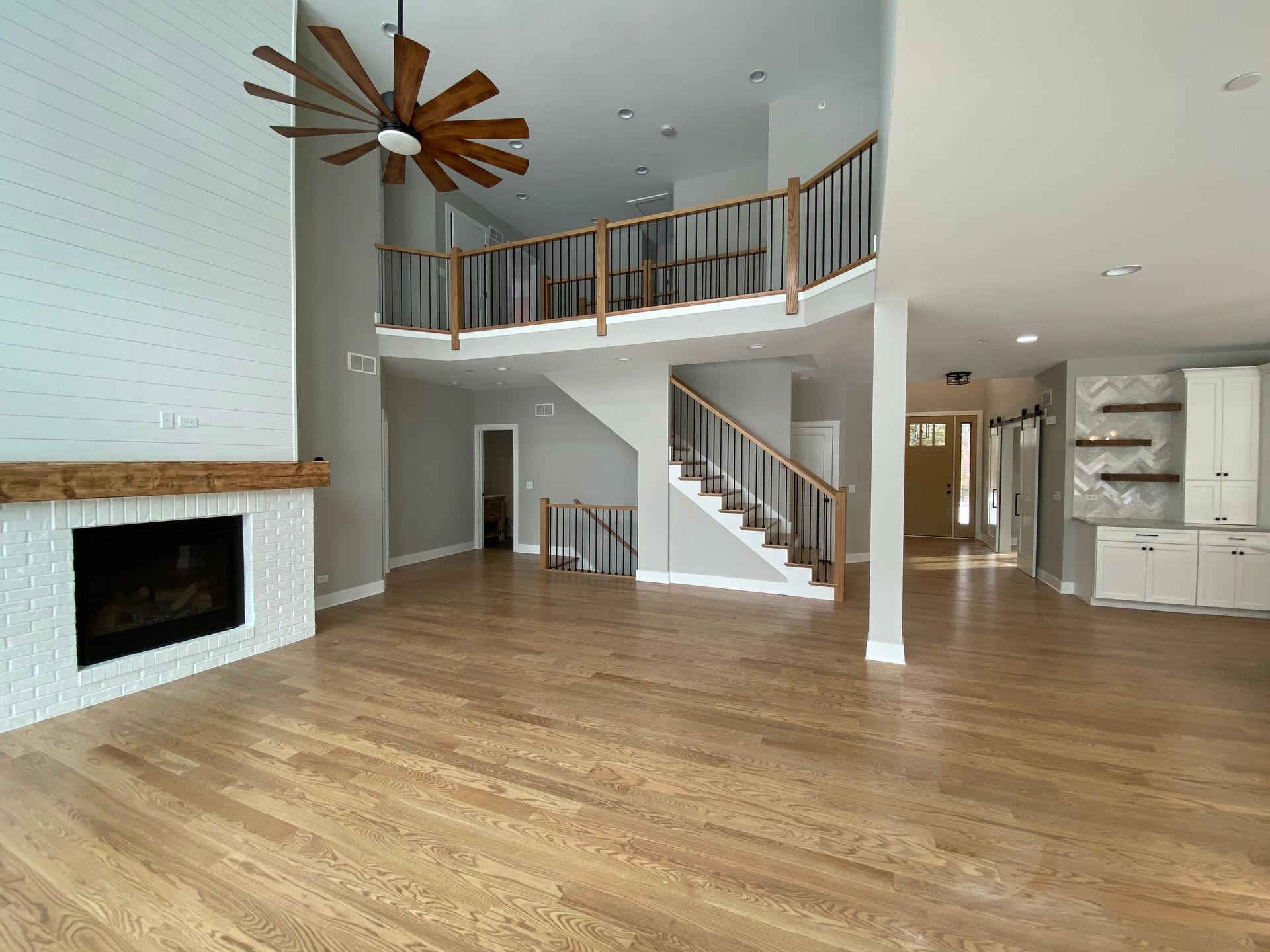 An empty living room with hardwood floors and a fireplace.