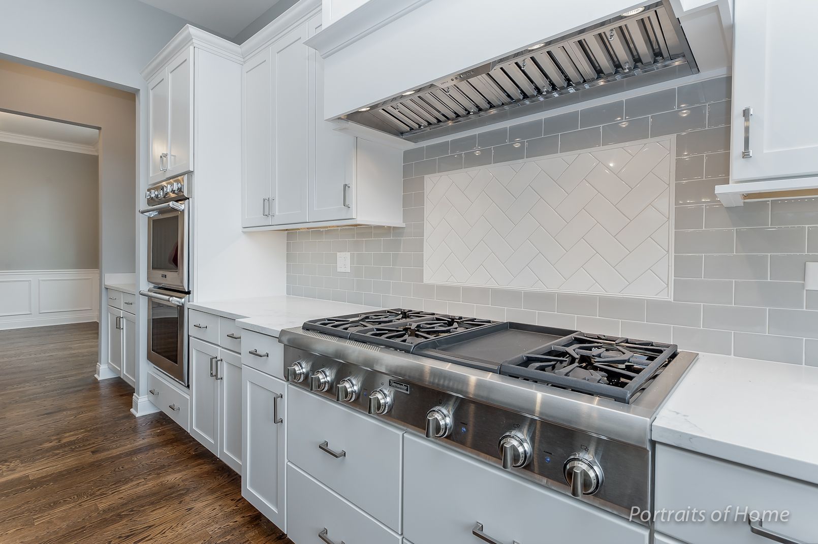 A kitchen with white cabinets and a stove top oven.