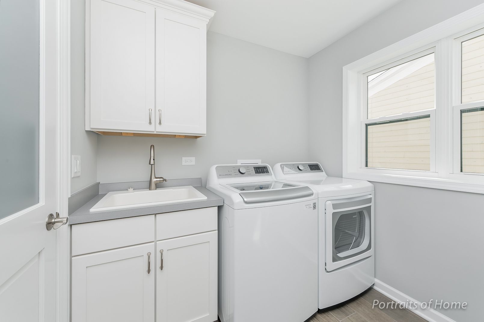 A laundry room with a washer and dryer and a sink.
