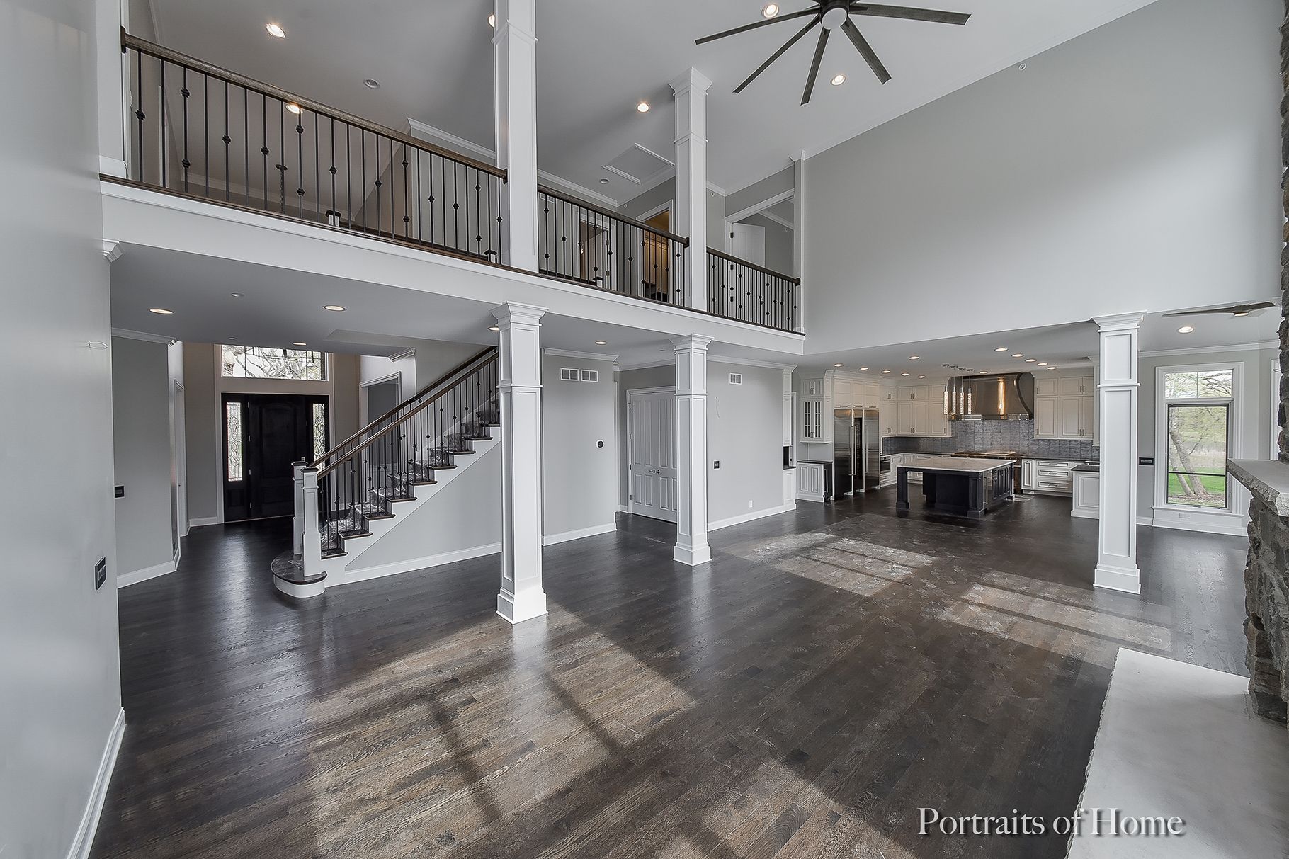 A large empty room with a staircase and a ceiling fan