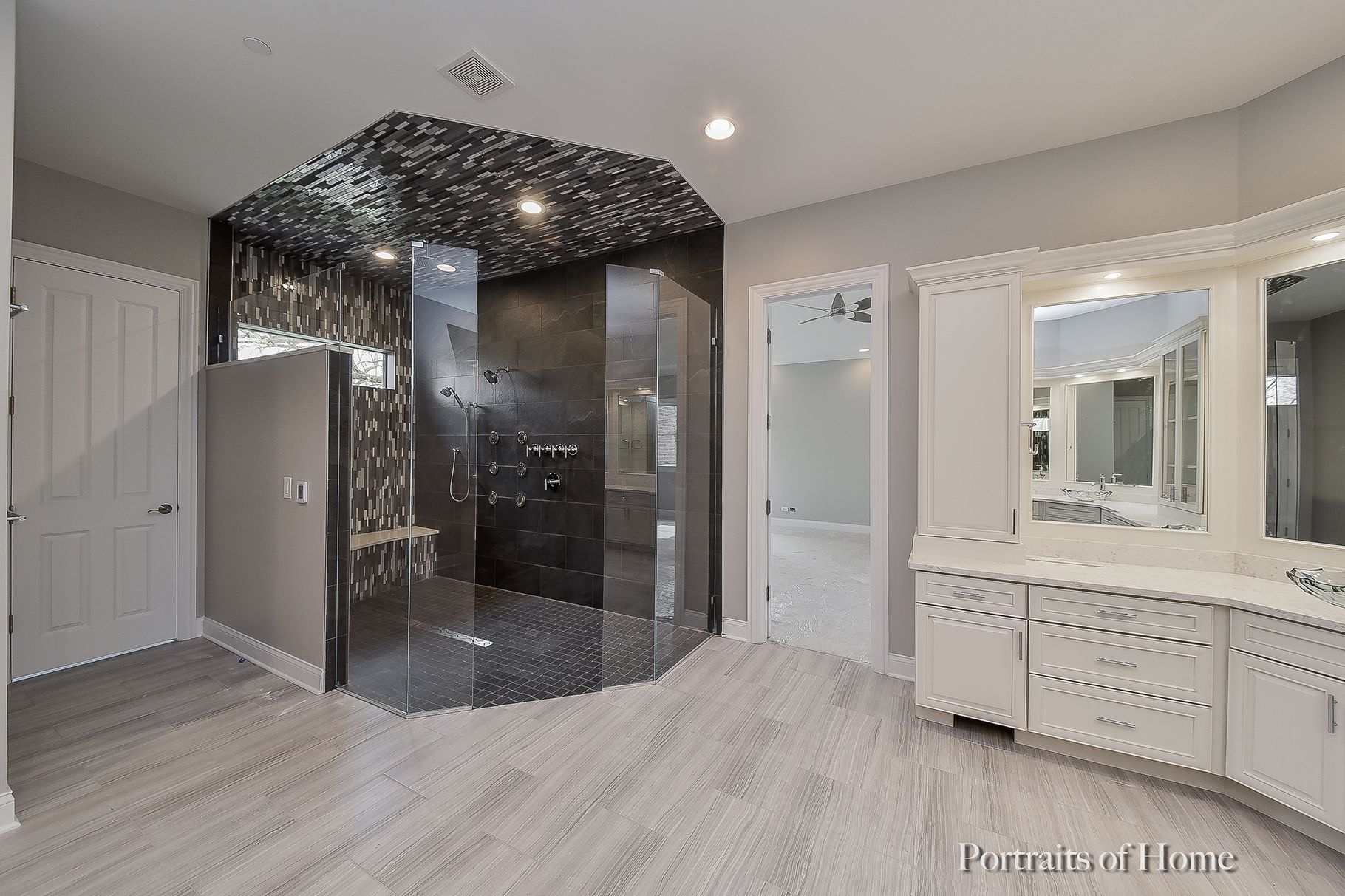 A bathroom with a walk in shower and two sinks.