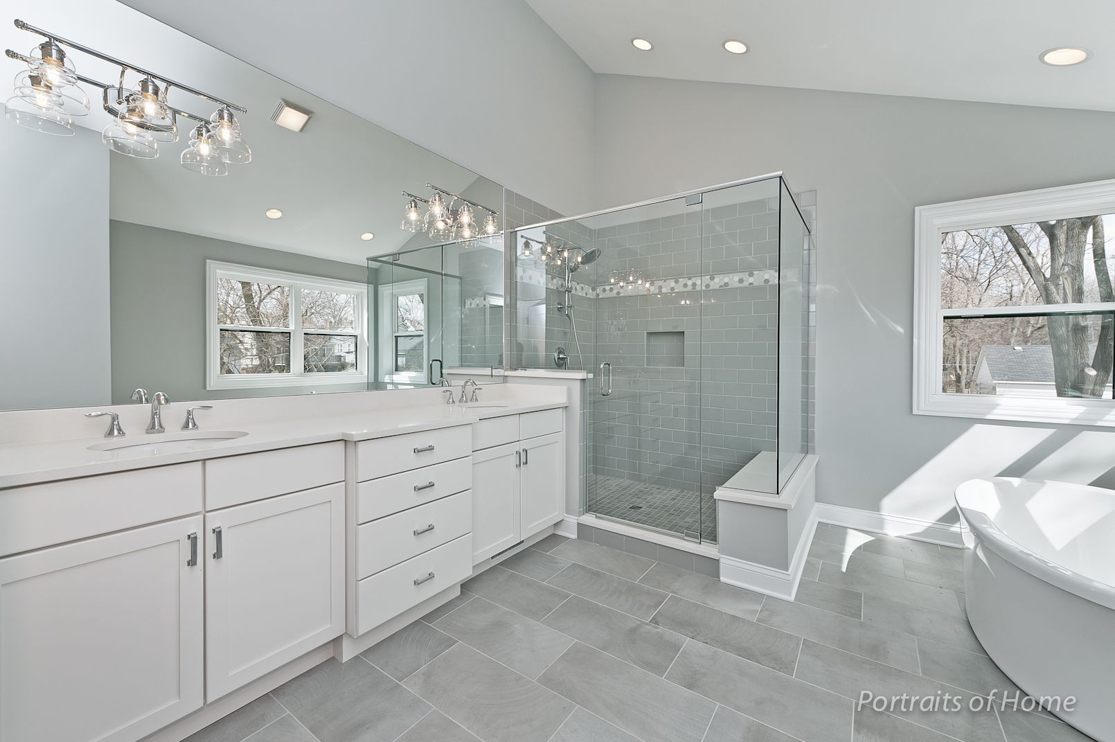 A bathroom with two sinks and a walk in shower