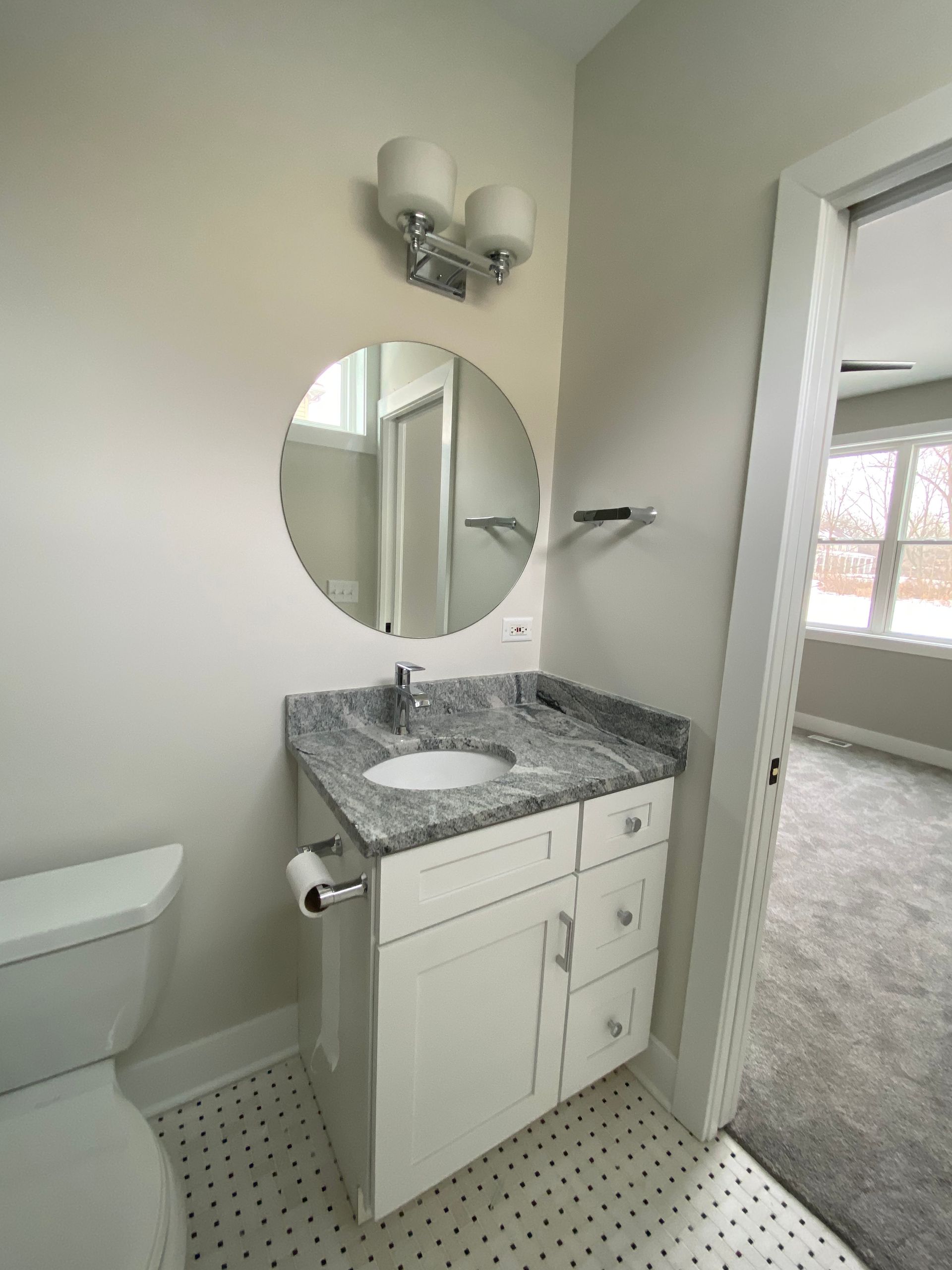 A bathroom with a toilet a sink and a mirror