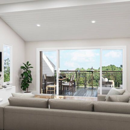 A living room with a couch and sliding glass doors leading to a balcony.