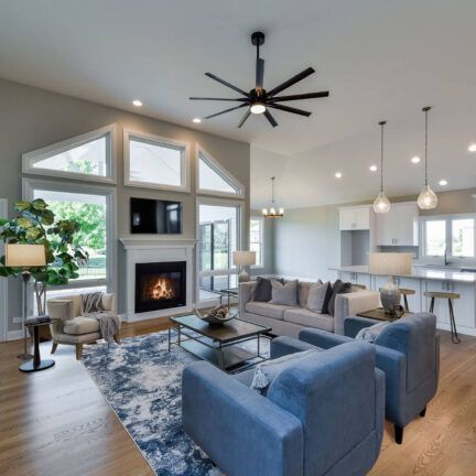 A living room with a fireplace and a ceiling fan