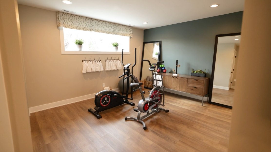 A home gym with a bicycle and a mirror.