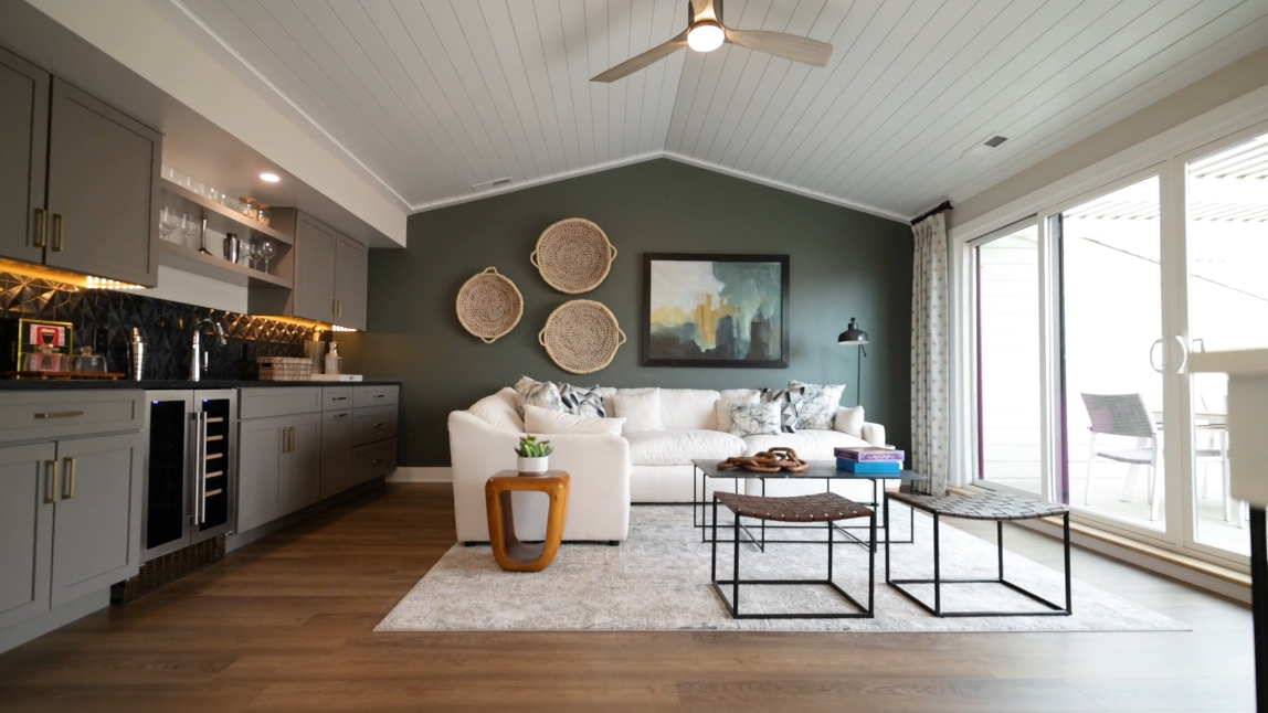 A living room with a couch , coffee tables , and a ceiling fan.