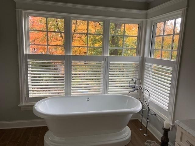 A bathtub is sitting in front of a window in a bathroom.