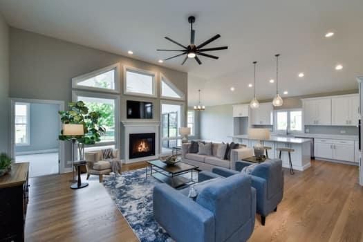 A living room with a fireplace and a ceiling fan