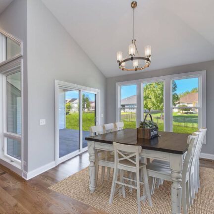 A dining room with a table and chairs and a chandelier hanging from the ceiling.