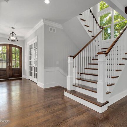 A white staircase with wooden steps in a house