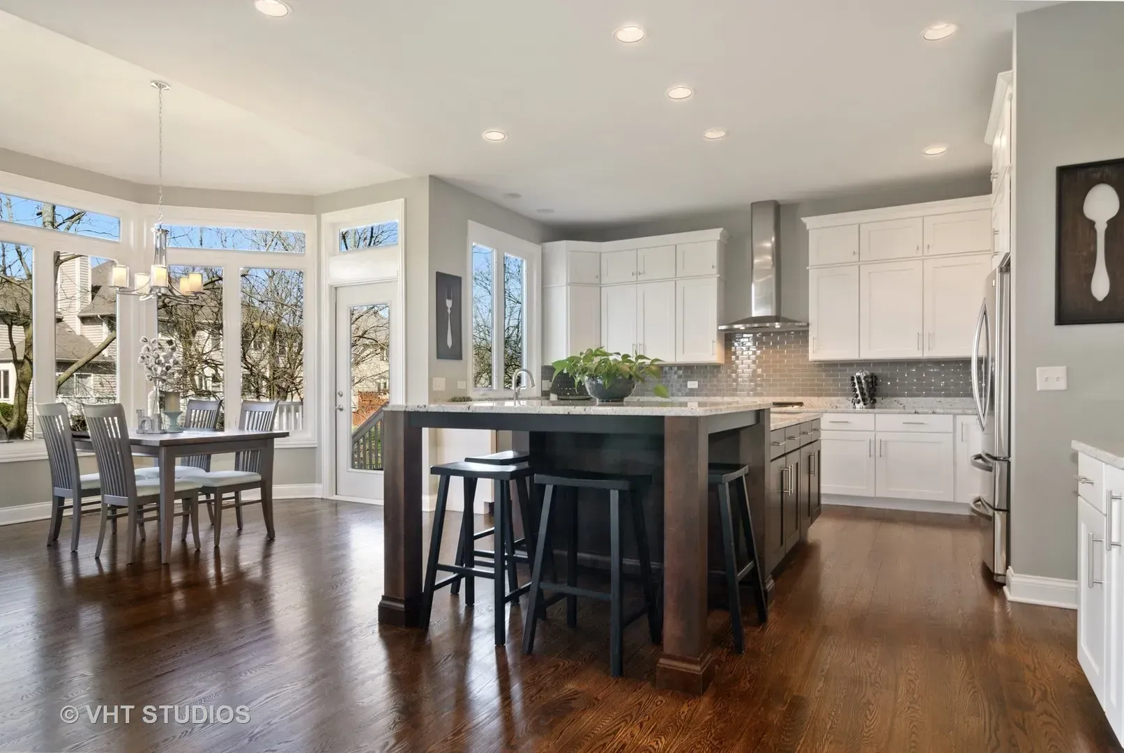 A kitchen with a large island and white cabinets