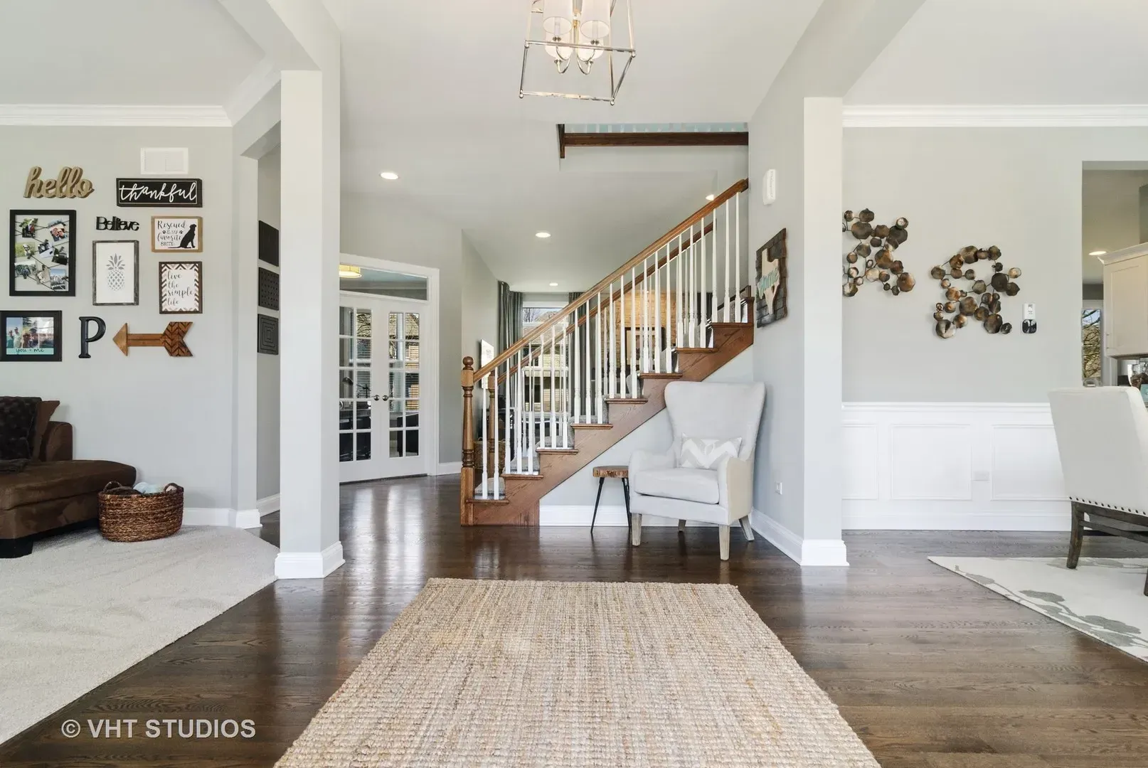 A living room with a staircase and a rug