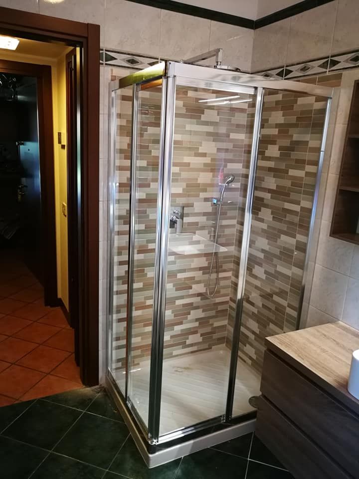 Un bagno con cabina doccia e lavandino.