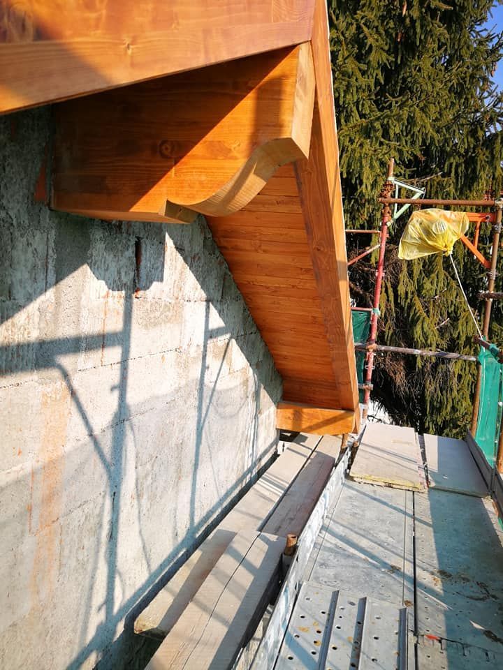 Una trave di legno è posizionata sopra un muro di cemento.