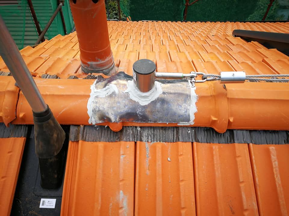 Un tetto con tegole arancioni e sopra un tubo