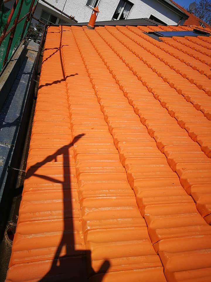 Un primo piano di un tetto di tegole arancioni con un camino sopra di esso.