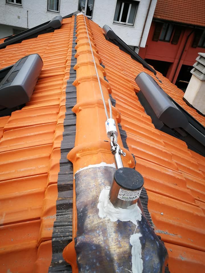 Un tetto con tegole arancioni e una corda attaccata ad esso