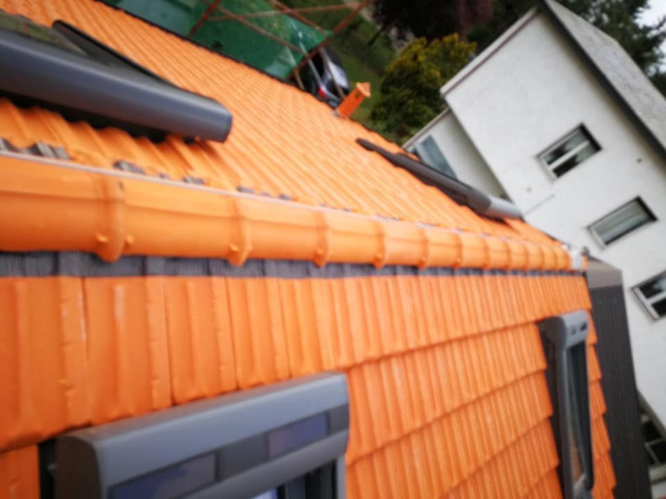 Un tetto con tegole arancioni e una finestra