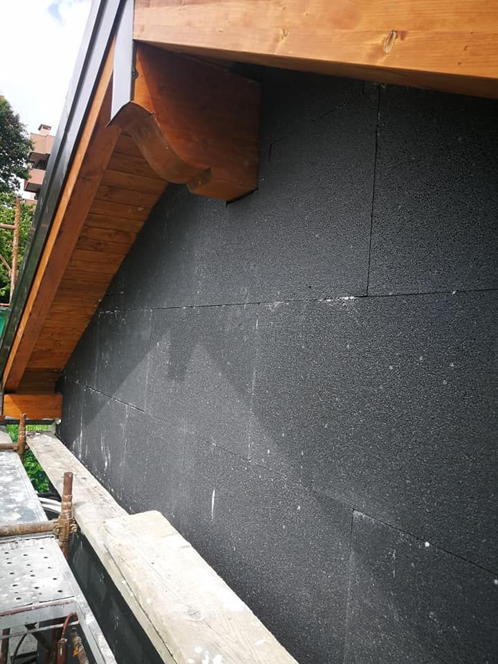 Un edificio con il tetto in legno e un muro nero