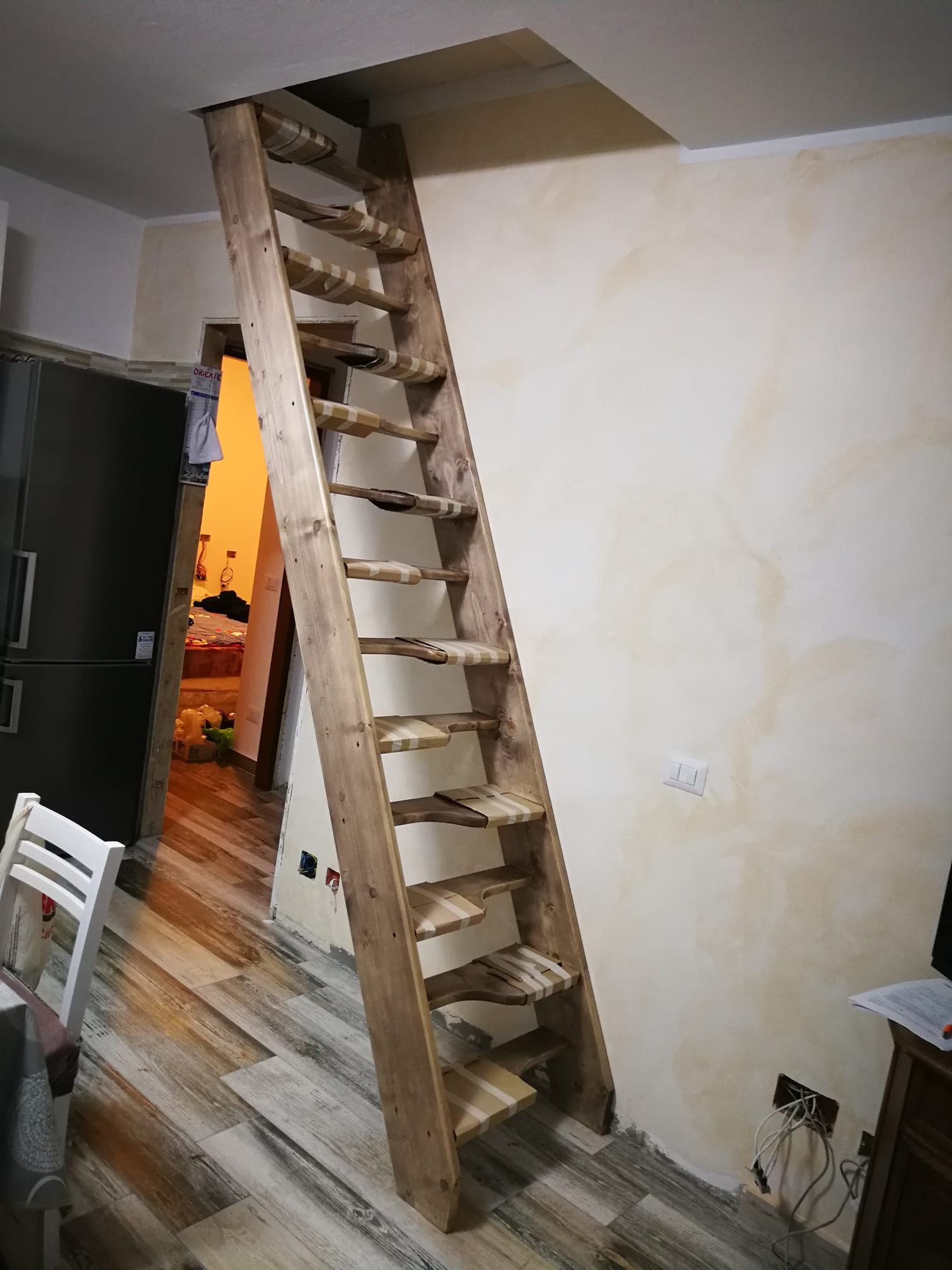 Una scala in legno che porta al secondo piano di una casa.