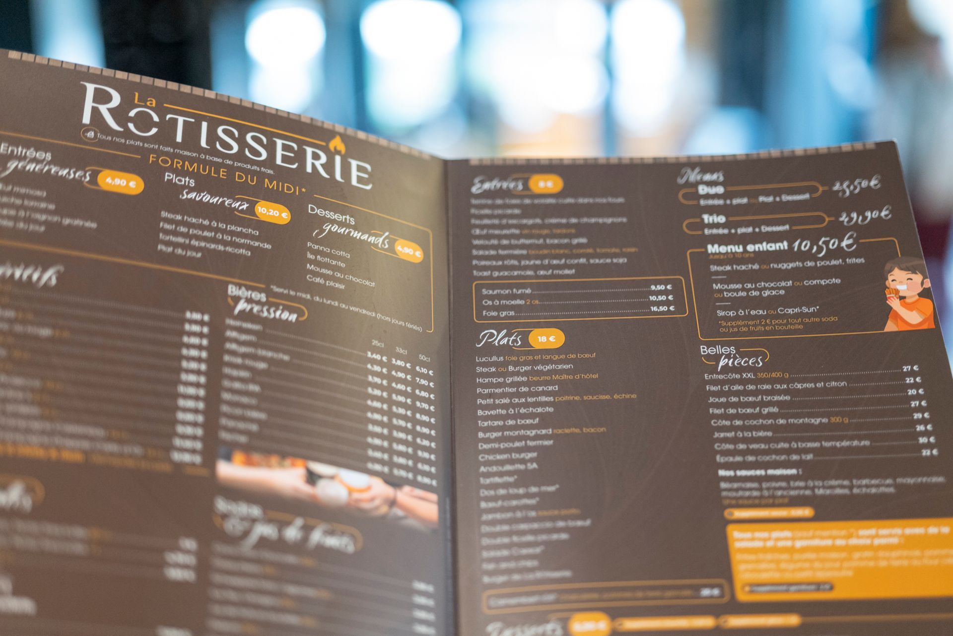 Menu ouvert du restaurant « Rôtisserie », texte marron et blanc sur fond sombre.