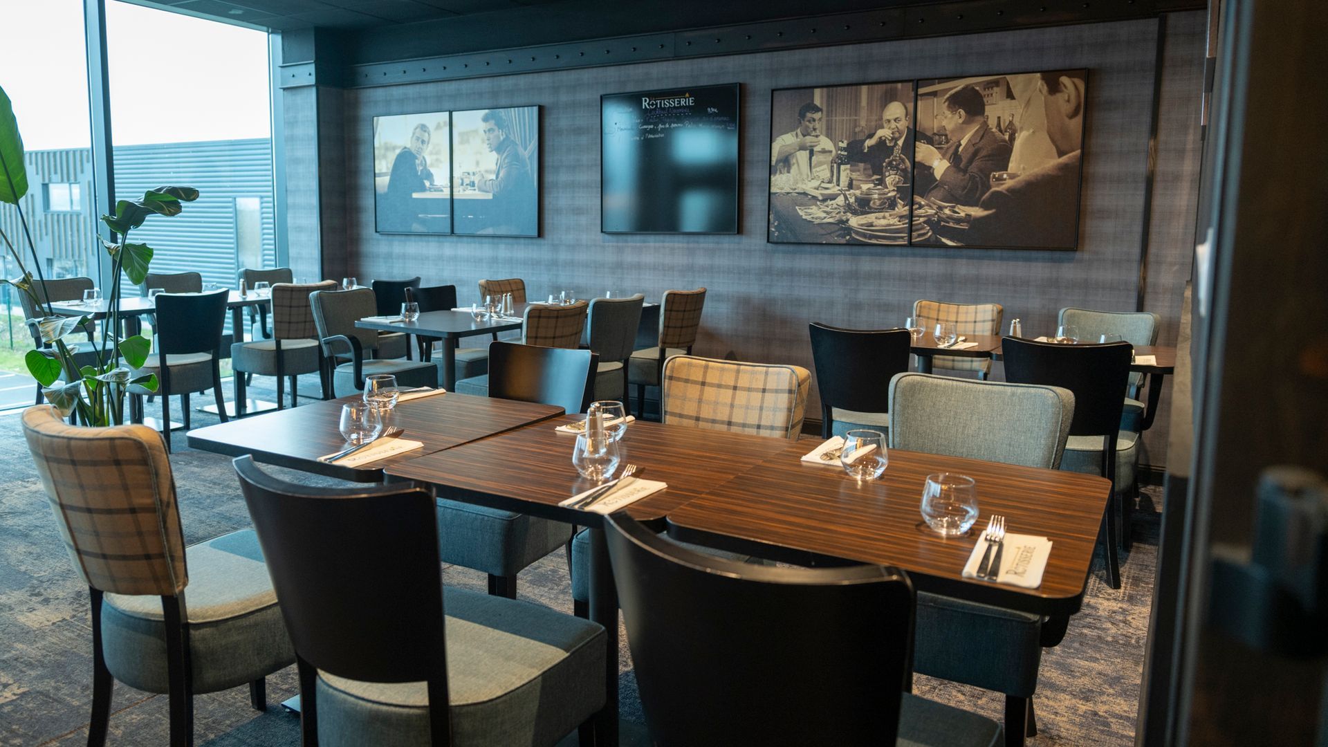 Un groupe de professionnels, les bras levés en signe de célébration, sourient dans un bureau plongé dans l'obscurité.