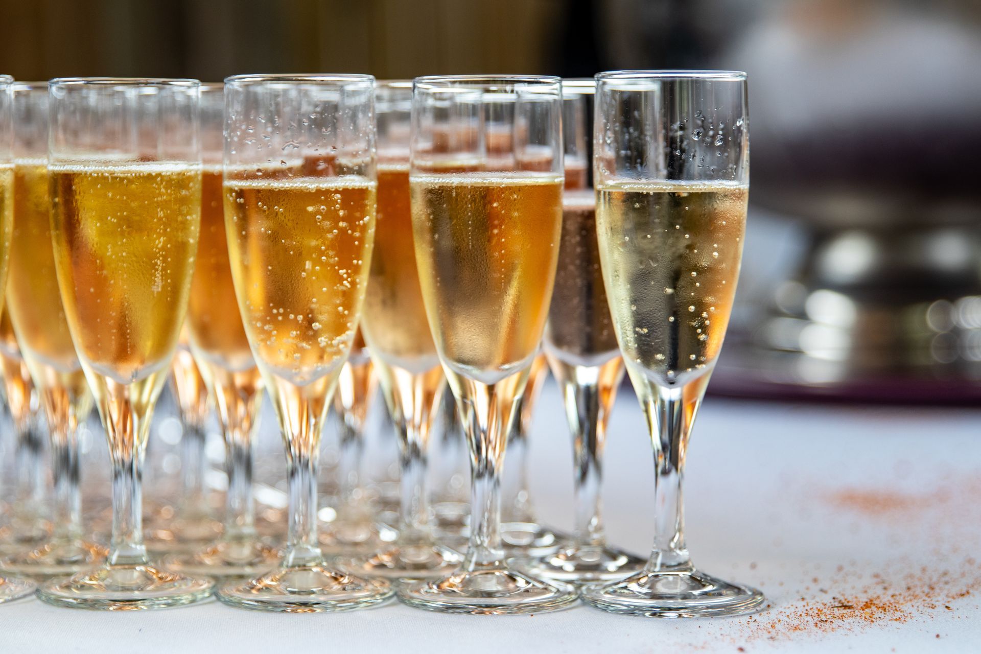 Des verres de vin mousseux alignés, avec des bulles.