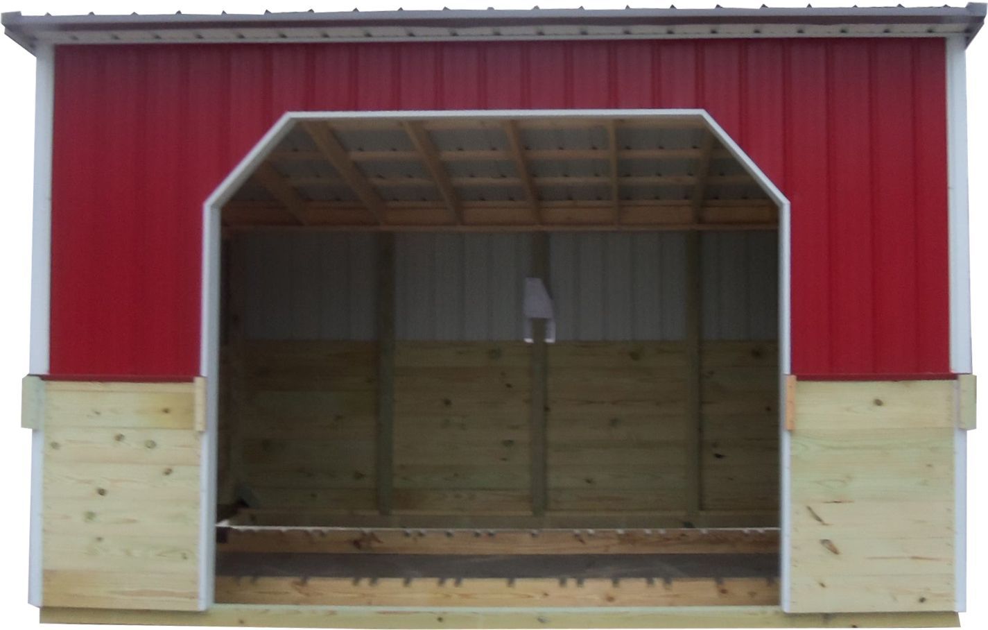 Red barn-style shed with a wide open doorway and wood-paneled lower walls
