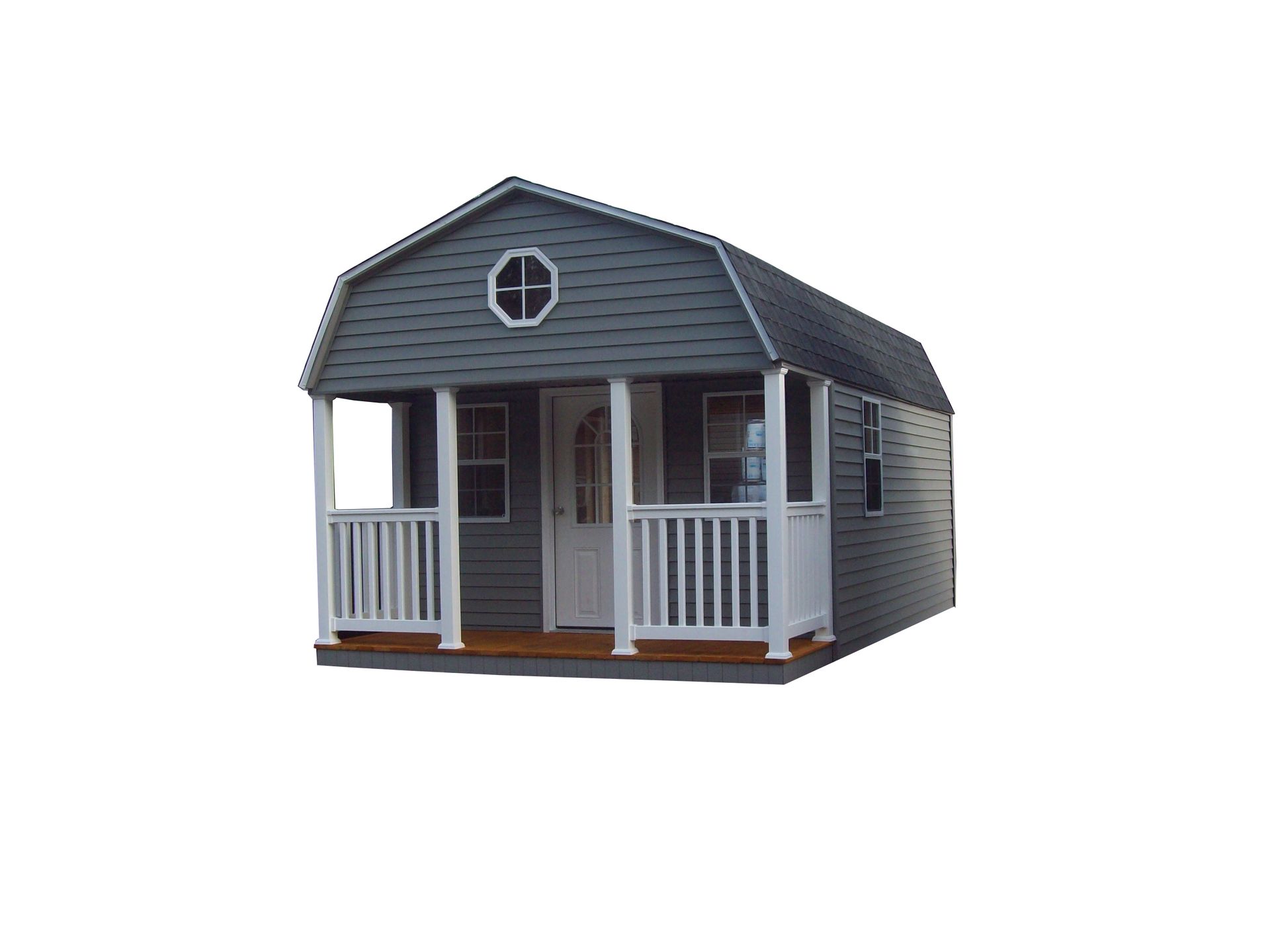 Small gray backyard shed with white porch railings and a round window on the front.