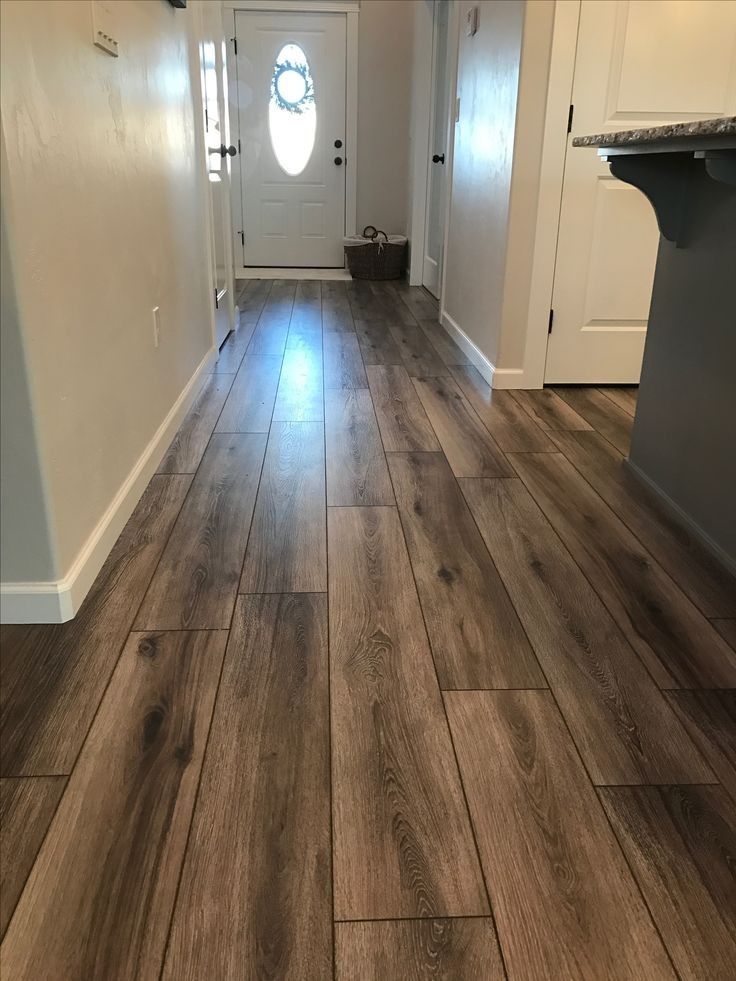 A hallway with hardwood floors and a white door.