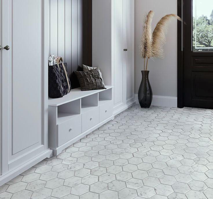 A hallway with a hexagonal tile floor and white cabinets