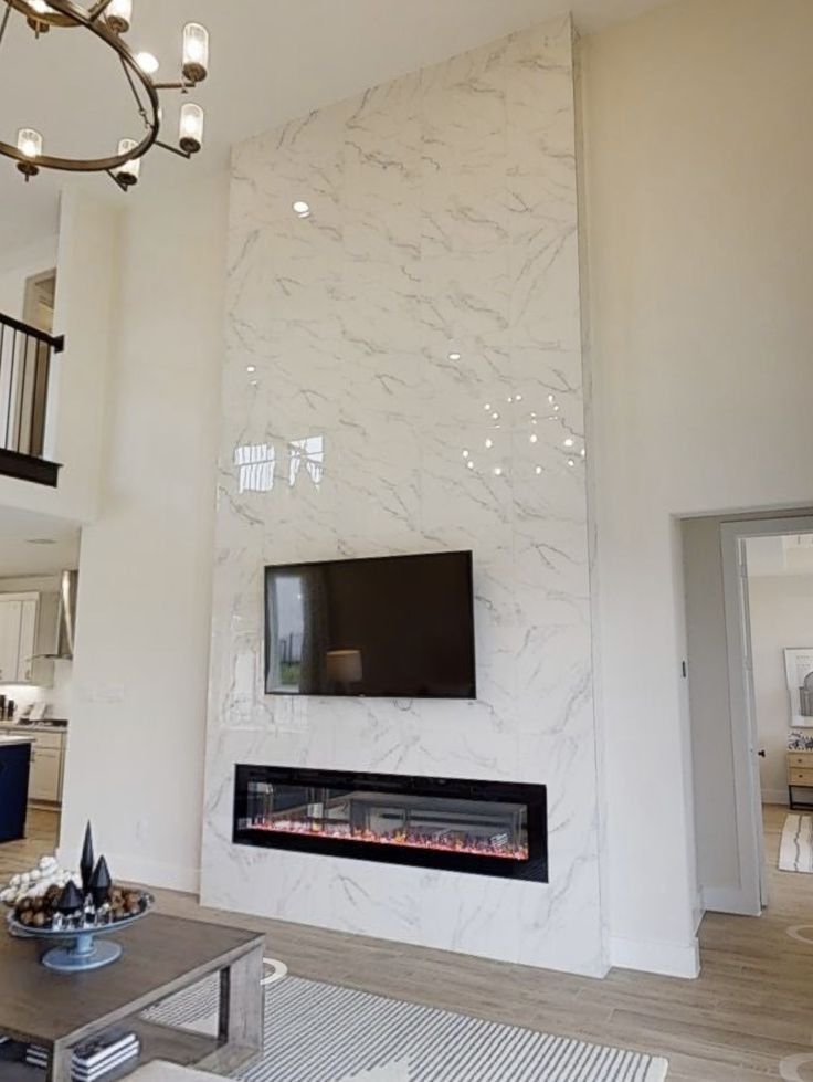 A living room with a fireplace and a flat screen tv on the wall.