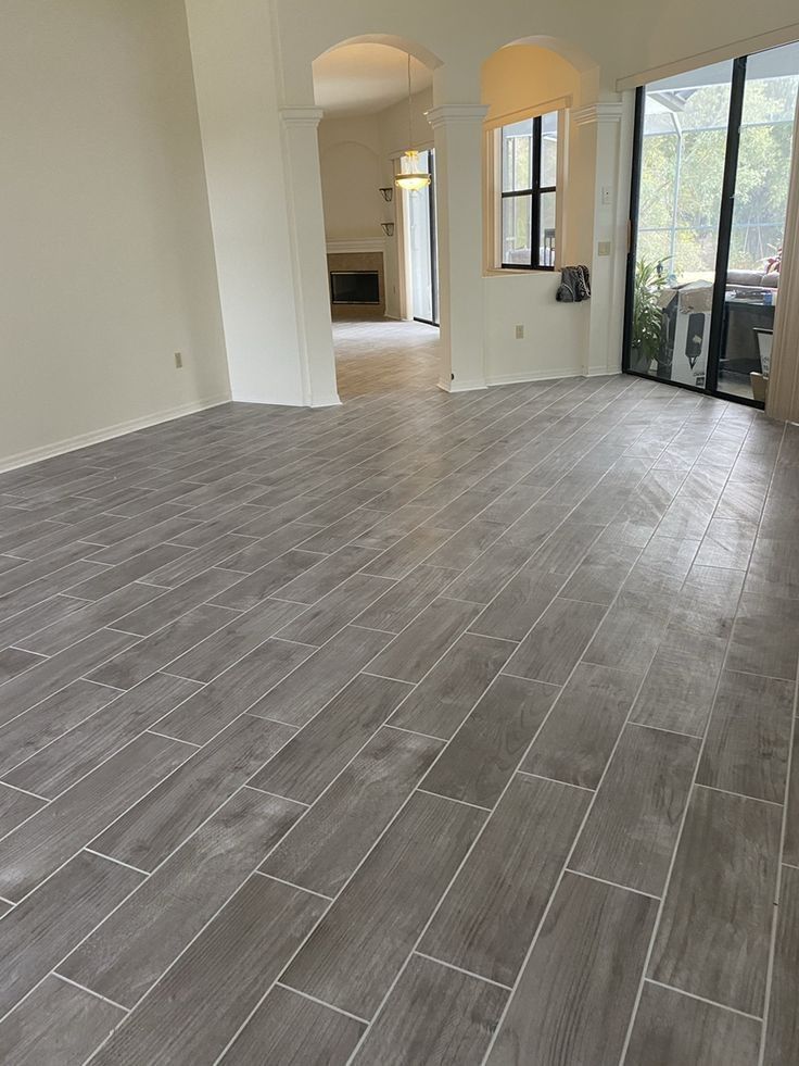 A living room with a gray tile floor and white walls.