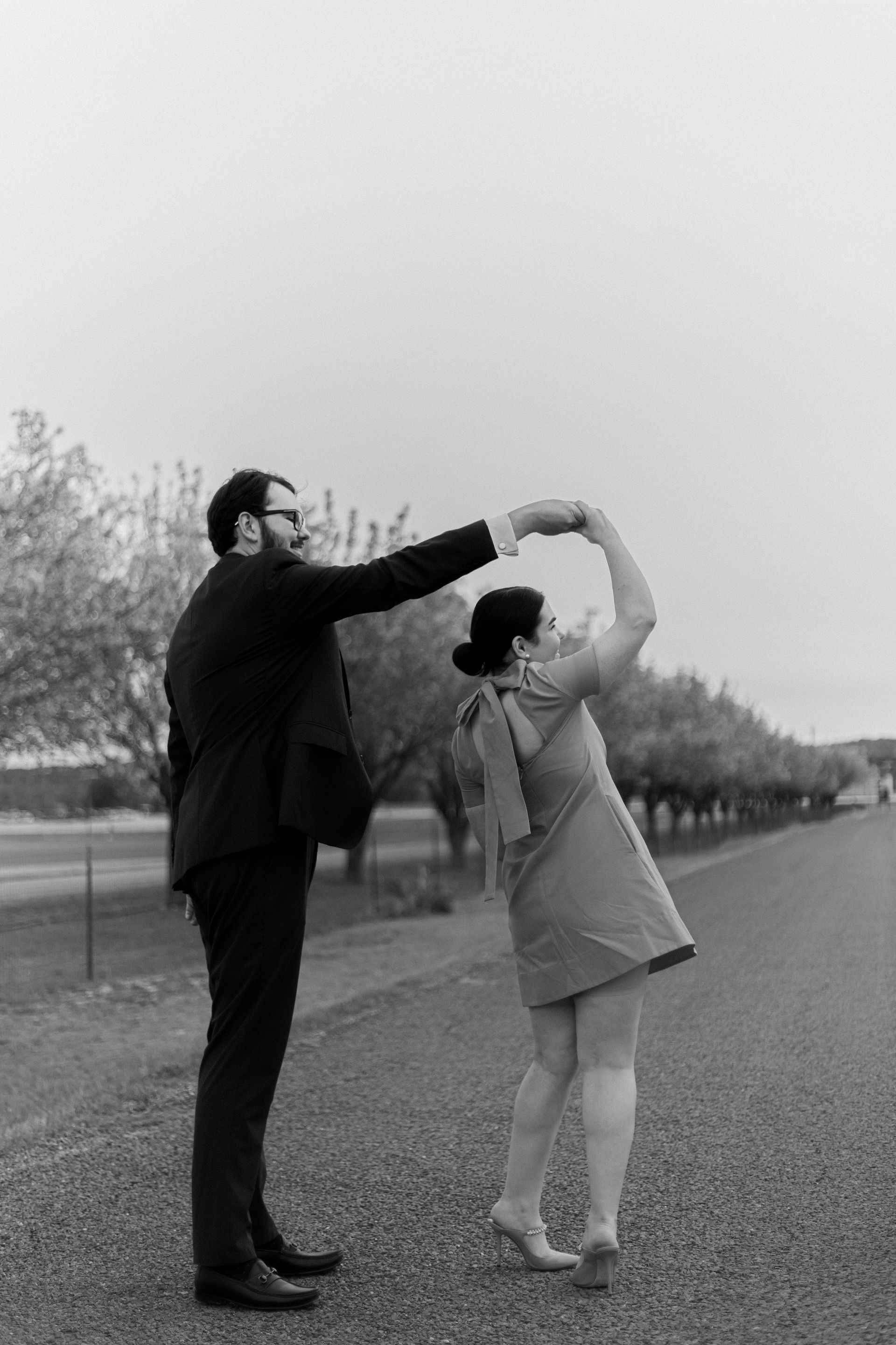 A man and a woman are dancing on the side of a road.