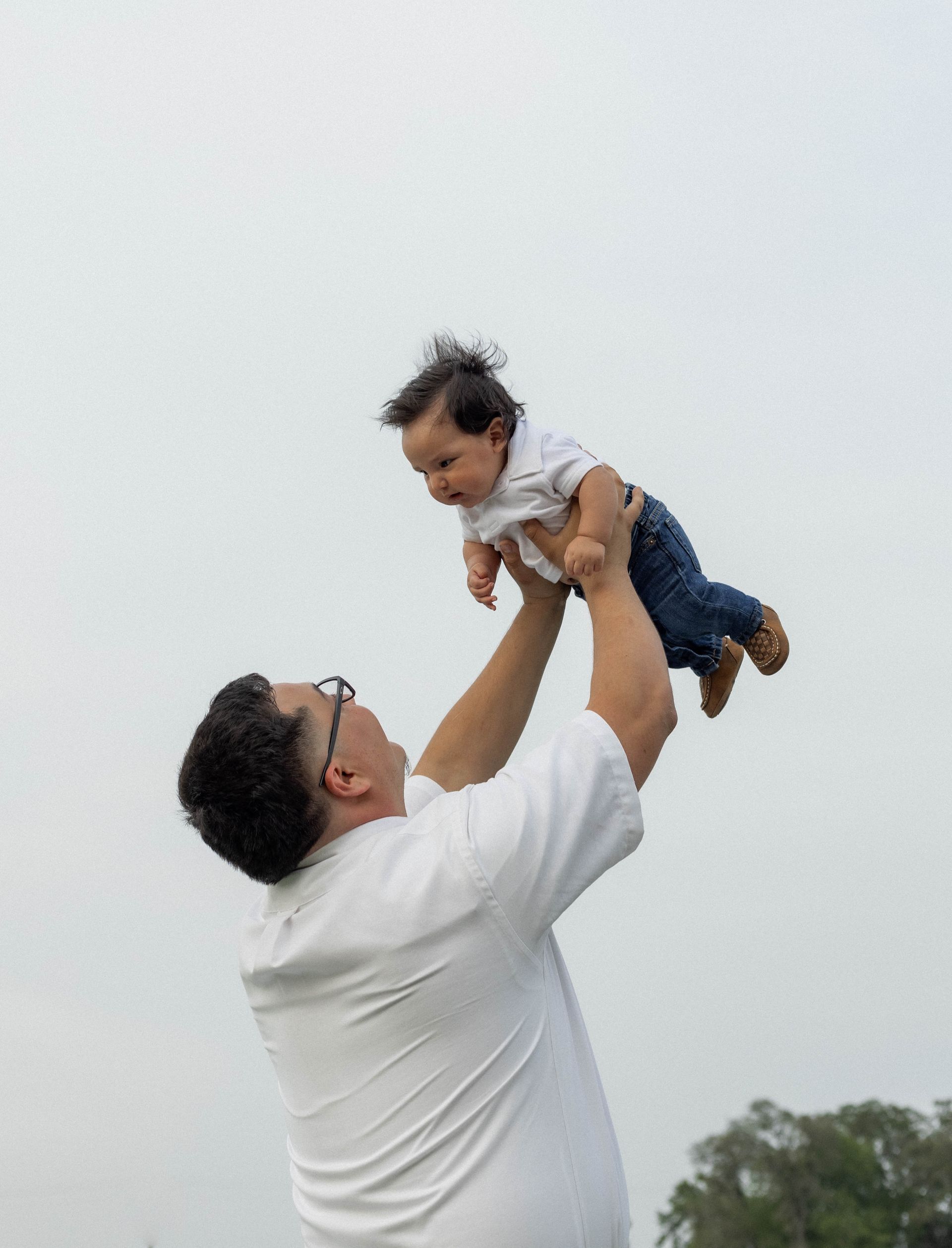 A man is holding a baby up in the air