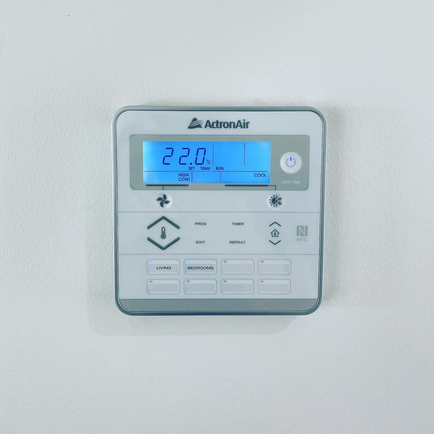 Wall-mounted Adornair thermostat with blue-lit display showing 22.0°C — Airset Air Conditioning in Macksville, NSW