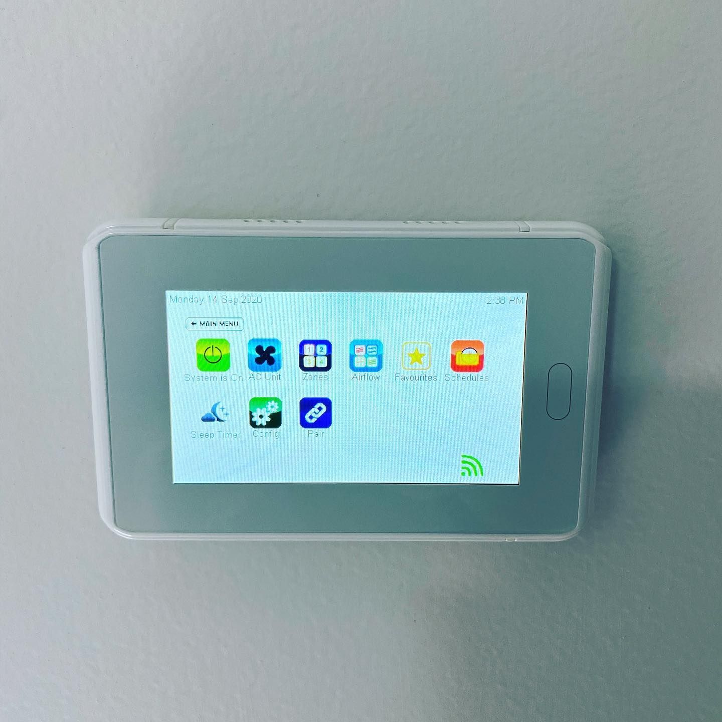Wall-mounted tablet displaying a smart home control screen with colourful app icons on a grey wall — Airset Air Conditioning in Macksville, NSW