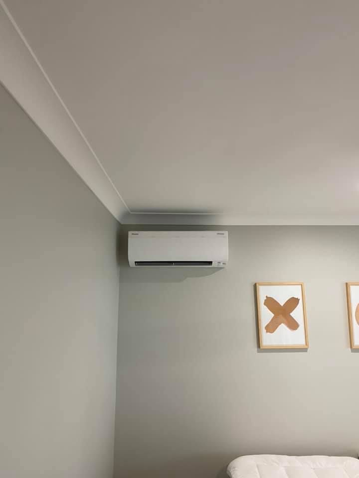 White Air Conditioner Mounted on a Light Gray Wall — Airset Air Conditioning in Bonville, NSW