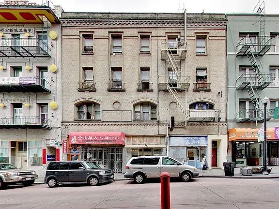 A white van is parked in front of a building
