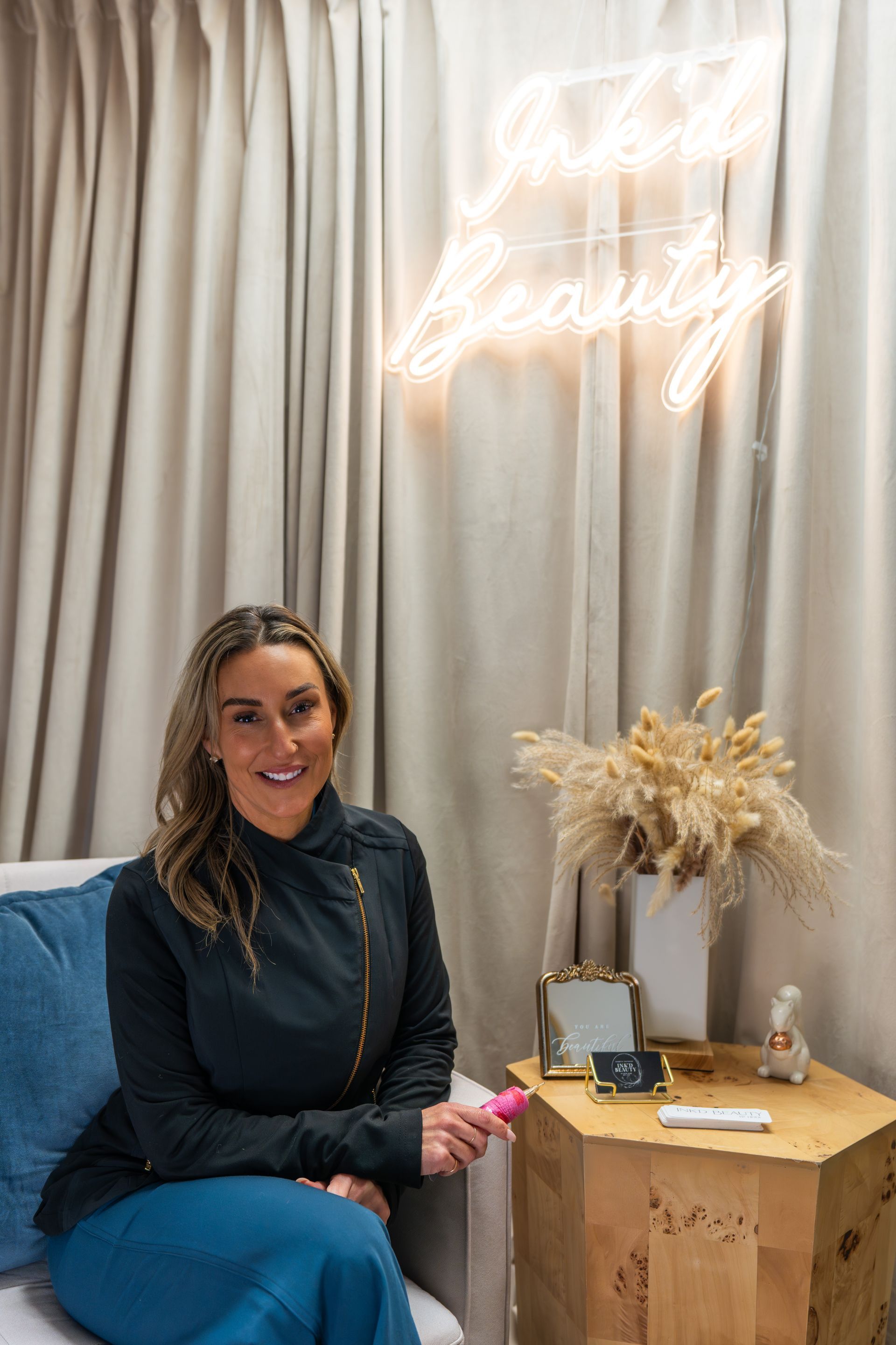 A woman in a white lab coat is smiling for the camera.