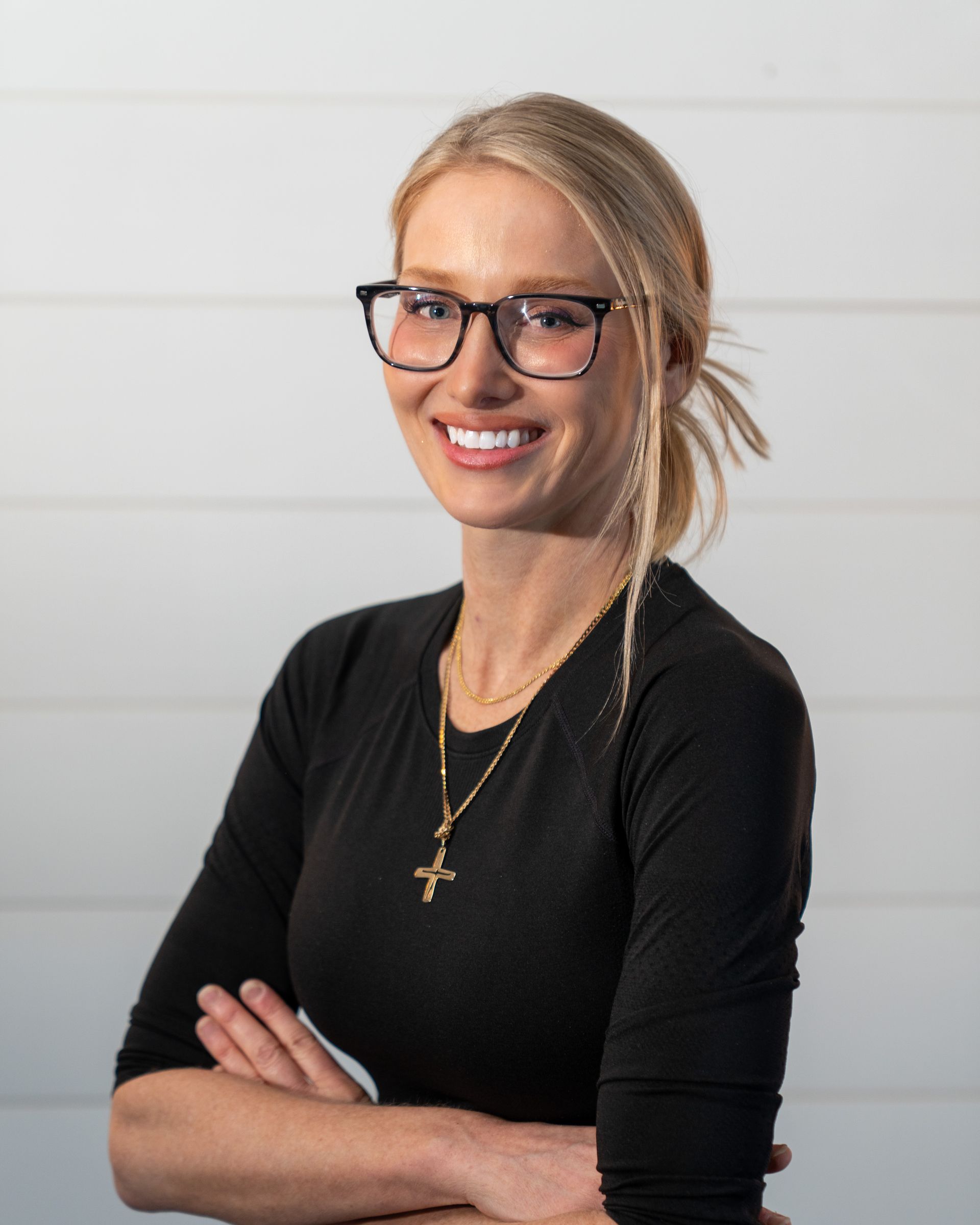 A woman in a white lab coat is smiling for the camera.