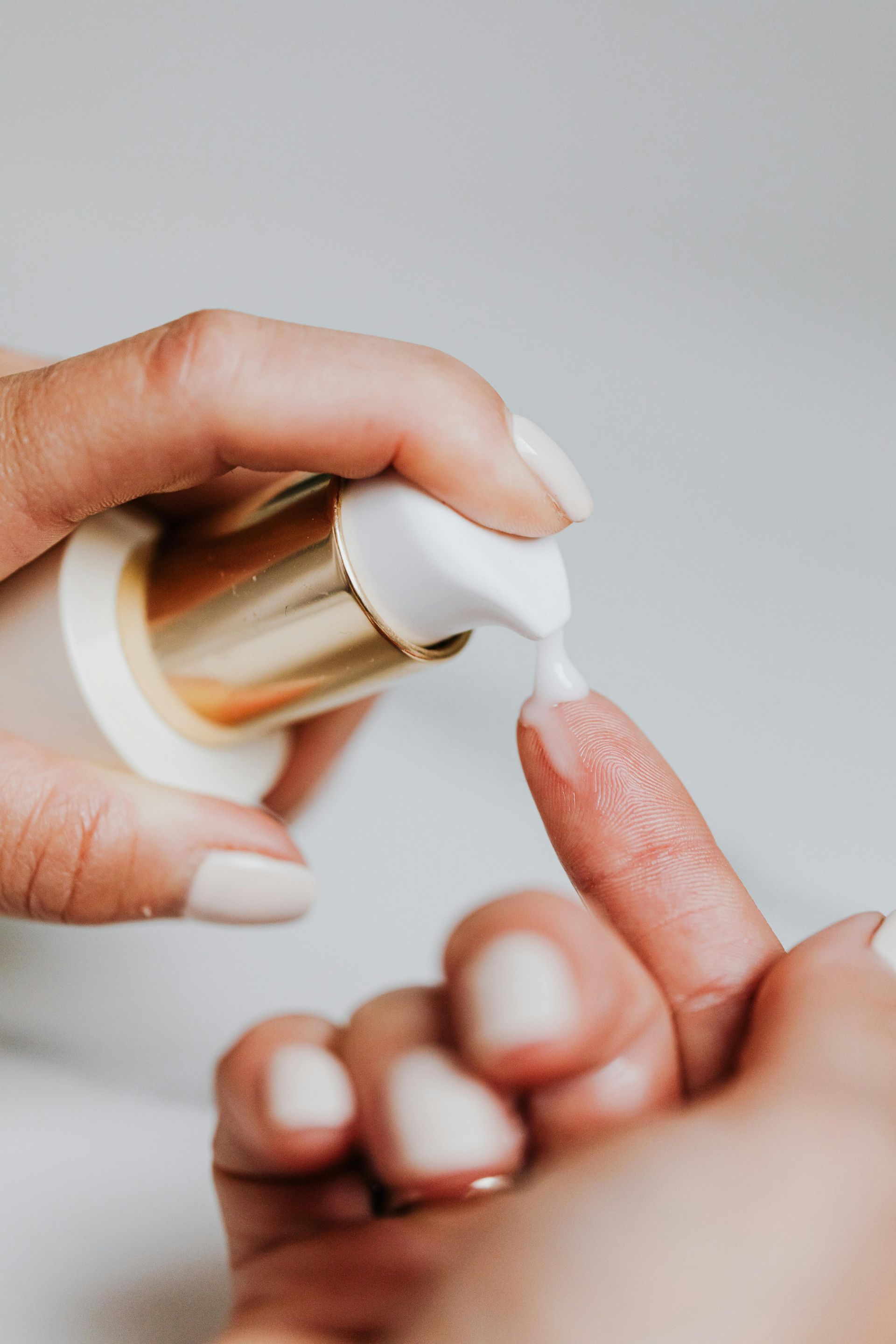A woman is applying lotion to her finger.