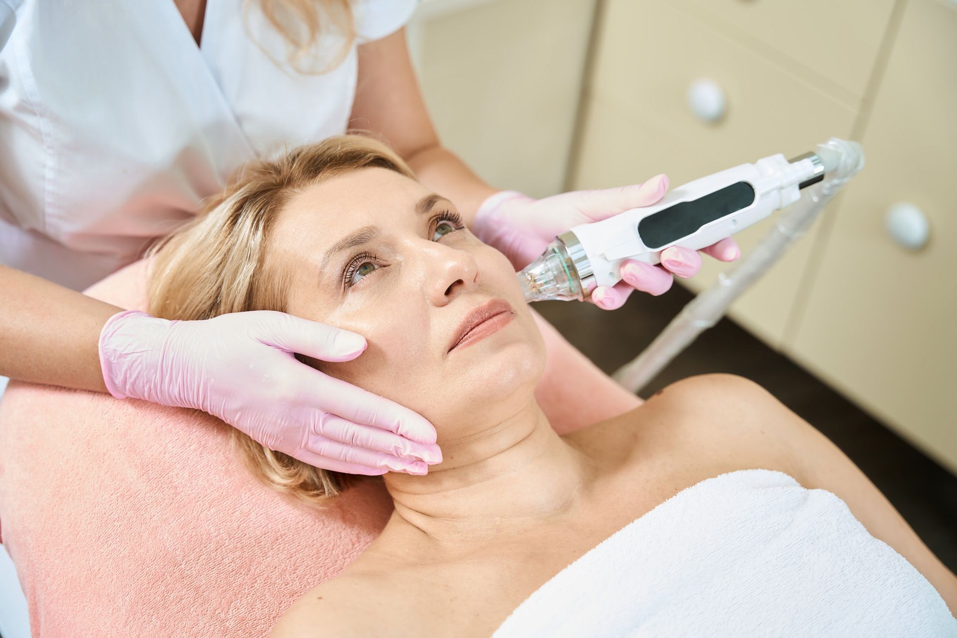 A woman is getting a facial treatment in a beauty salon.